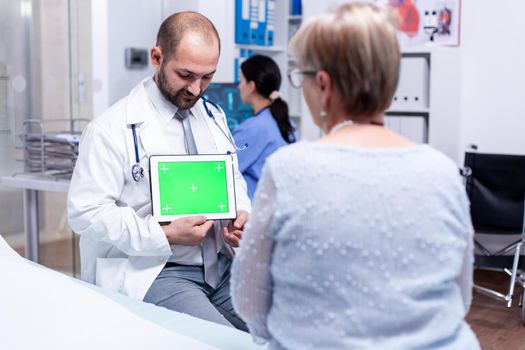 Medical practitioner with green screen tablet