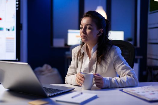 Workaholic businesswoman analysing economic statistics late at night