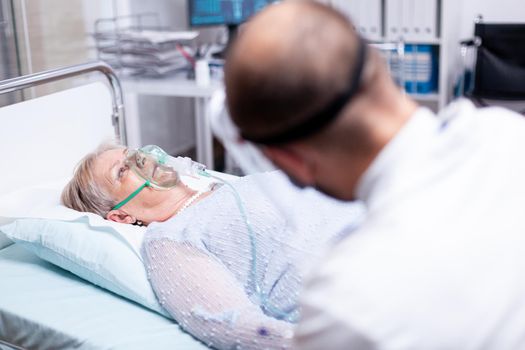 Senior woman breathing with oxygen mask