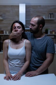 Aggresive husband being cruel to bruised wife at home