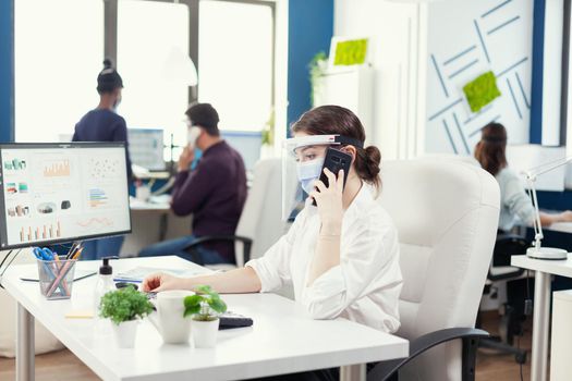 Business woman in office wearing face mask against covid 19