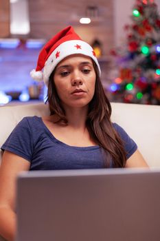 Girl reading business email on laptop computer working during christmastime