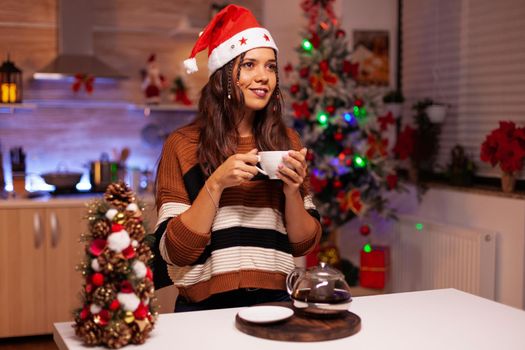 Festive woman holding cup of tea thinking about festivity