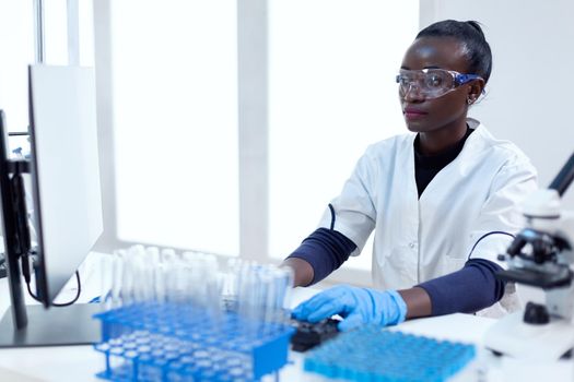 African biotechnology researcher works in bright modern laboratory