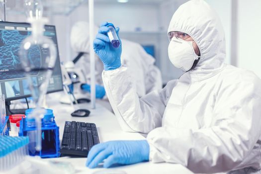 Lab technician dressed in protective suit as safety precaution