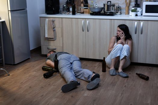 Couple dealing with alcohol addiction laying on floor