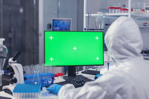 Researcher developing cure for covid19 using pc with green screen
