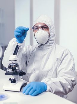 Medical chemist holding microscop glass slide with blood sample