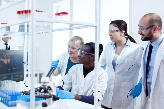Group of multiethnic pharmacy scientists in lab coats working together