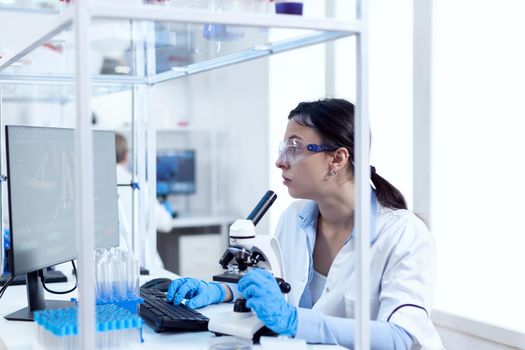 Laboratory technician working in microbiology lab using computer