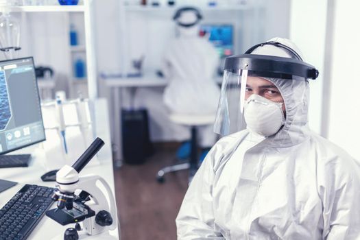 Tired chemical engineer in protection suit against infection