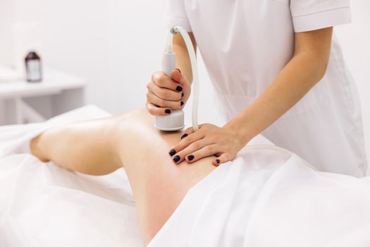 Woman getting anti-cellulite and anti-fat therapy in beauty salon. Hardware cosmetology. Body care. Spa treatment. Legs anti-cellulite procedures. woman health and beauty.