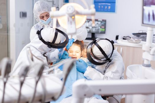 Little girl screaming in the course of painfull cavity treatment