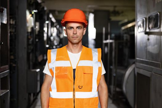 Male Inspection Person in Protective Hardhat Wear. Engineer Planning Manufacture Work. Blueprint of Confident Technical Foreman or Attractive Workman Mechanic near Modern Machine Tool Indoors