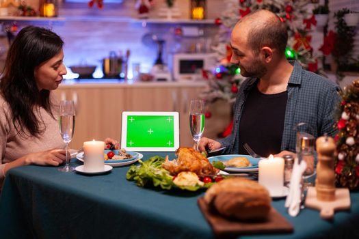 Happy family sitting at dining table in x-mas decorated kitchen