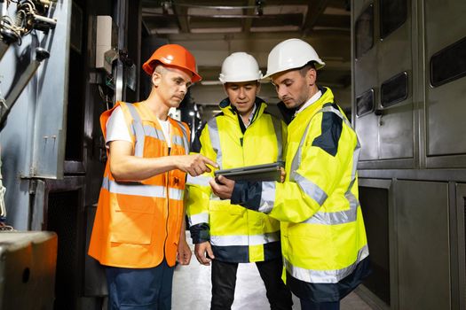 Three engineers men in uniform discuss use tablet, browsing building project indoor of construction site. Businessman worker, man male construction engineers or architects working people