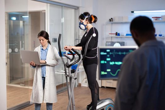 Team of professional doctors measuring health conditions of woman athlete