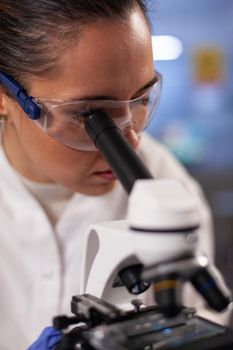 Experiment scientist analyzing sample on microscope