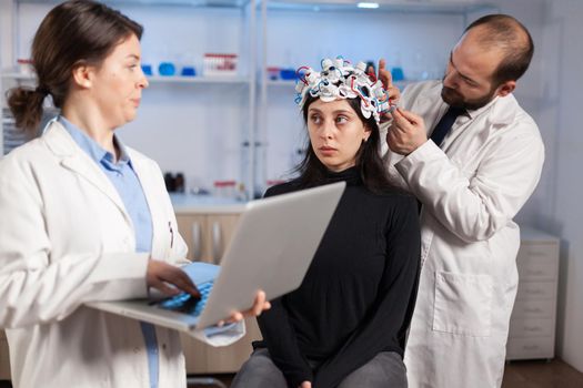 Expert medic in neuroscience developing brain experiment holding laptop