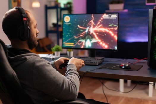 Concentrated gamer playing virtual game on powerful computer