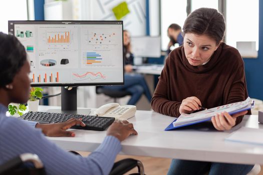 Diverse businesswomen planning financial strategy looking on computer