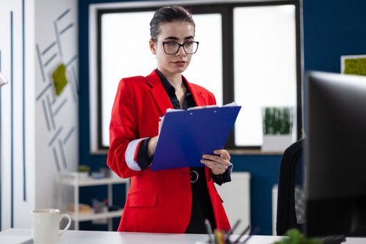 Entrepreneur standing in corporate office workplace taking notes