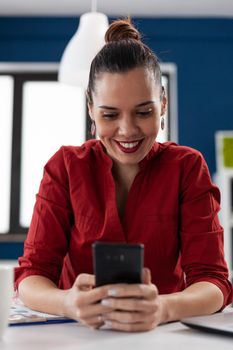 Happy cheerful excited businesswoman texting on smartphhone