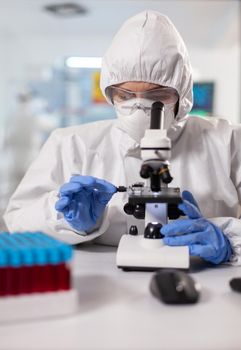 Genetic scientist looking at sample through microscope
