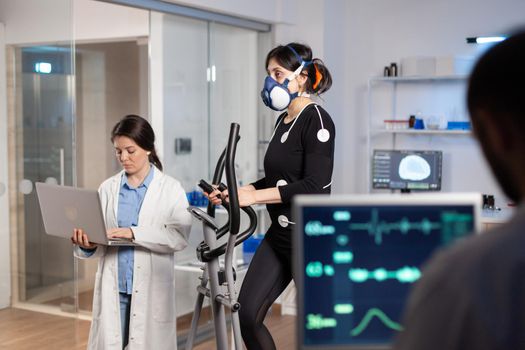 Team of medial researchers monitoring vo2 of woman performance