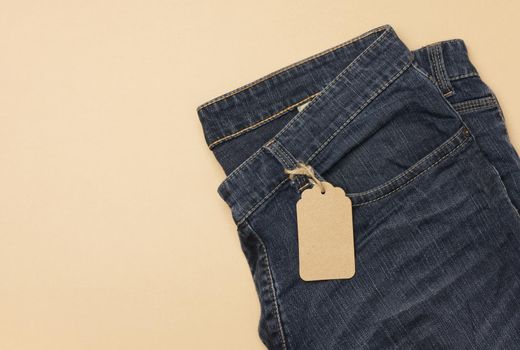blank cardboard rectangular tag tied to blue jeans.
