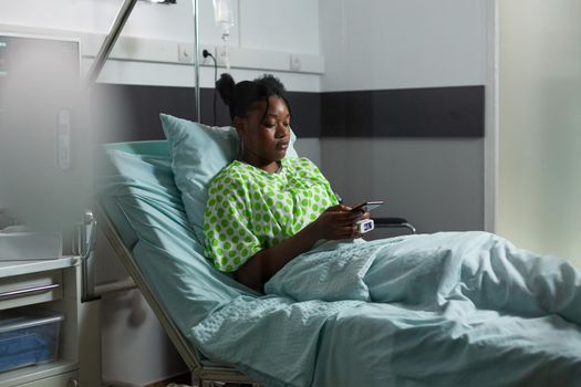 Young african american adult with sickness having smartphone