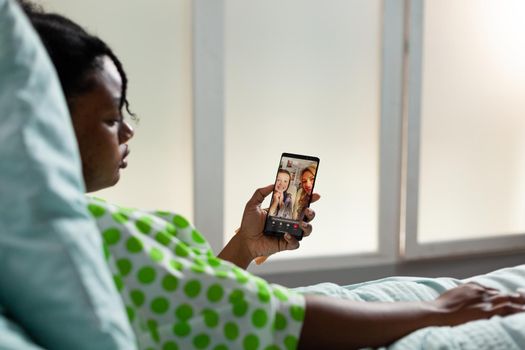 Patient of african american ethnicity using smartphone