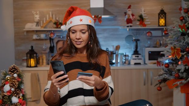 Festive woman using smartphone for shopping presents