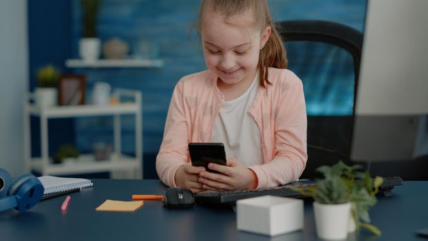Cheerful child looking at smartphone with touch screen