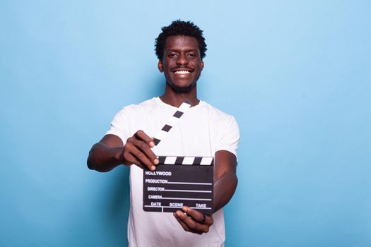 Portrait of man holding clapperboard to cut scenes