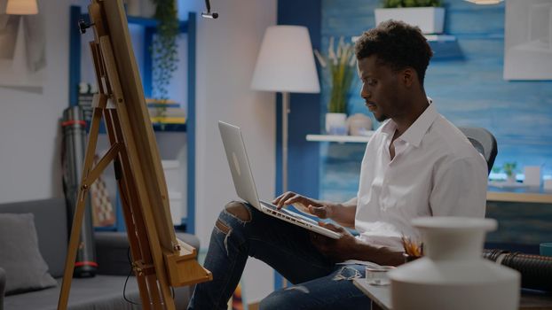 Black young artist using laptop technology for art concept