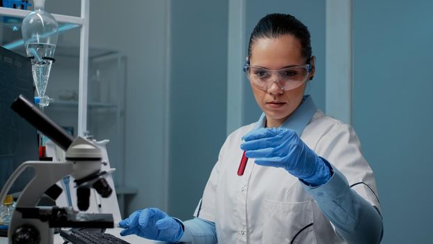 Microbiology doctor looking at vacutainer from tray