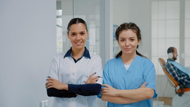 Dentist and nurse in medical uniform standing at dental clinic