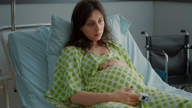 Portrait of pregnant adult holding hand on belly