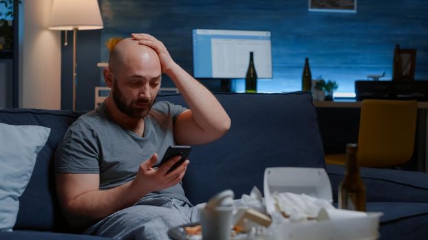 Shocked, worried man by warning notification for unpaid bank bills