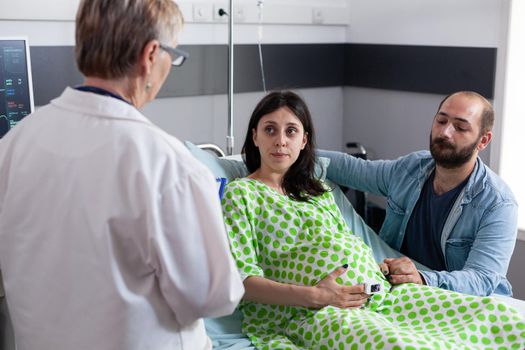 Obstetrics doctor talking to couple with pregnancy