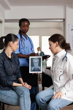 Specialist radiologist doctor analyzing clinical radiography with woman patient