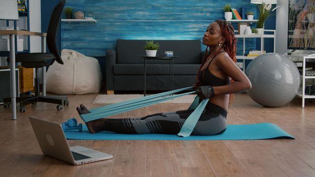 Athetic black woman in sportswear watching aerobic online sport workout
