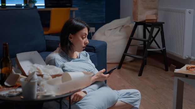 Lonely woman with anxiety and mental problems browsing on smartphone