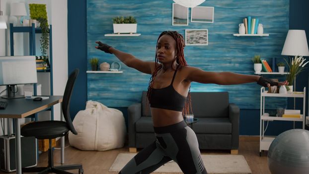 Athletic woman with black skin warming up before aerobic class