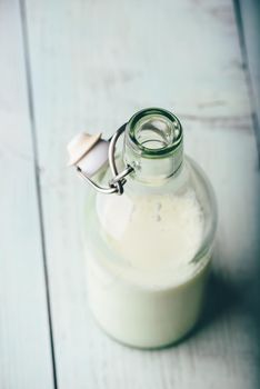 Milk in glass bottle on wooden surface