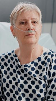 Portrait of retired woman with nasal oxygen tube and oximeter