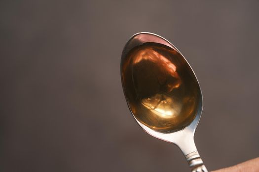 liquid medicine on a spoon on black background