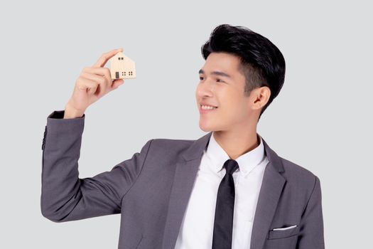 Young asian business man holding the home symbol of saving for future, insurance agent and credit, ownership house, debt and loan of finance, purchase home and refinance, investment real property.