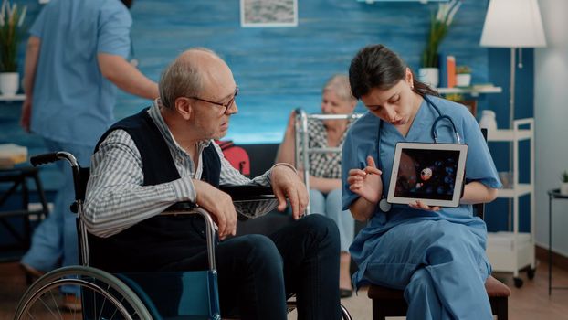 Patient with disability looking at virus animation on digital tablet